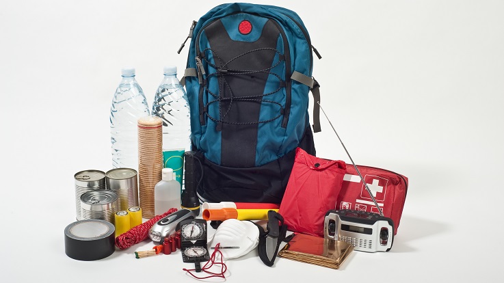 Foto eines Rucksacks, einer Erste-Hilfe-Ausrüstung, eines Radios, eines Wassers und anderer Nothilfen.