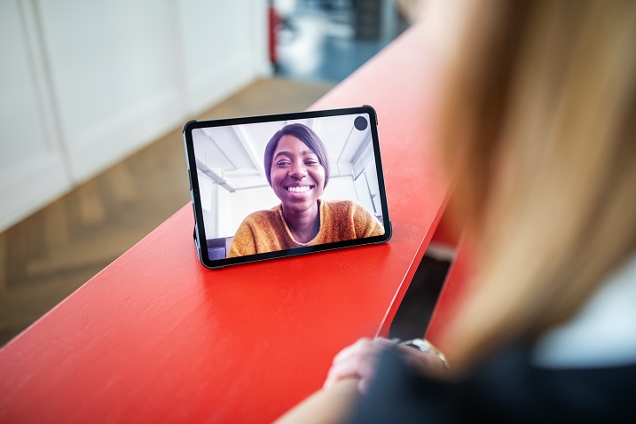 Foto einer Person, die ein Tablet mit Videokonferenzen verwendet