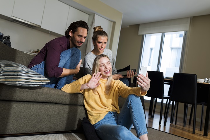 Foto von Freunden, die einen Videochat auf einem Gerät haben.