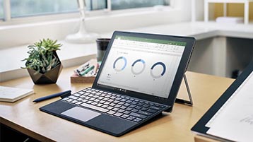 A desk with a Surface computer showing Excel charts