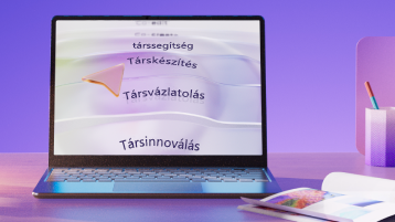 Laptop, amelyen a Co-author, a Co-assist, a Co-produce, a Co-draft és a Co-innovate szavak láthatók, hogy a Copilot képességeit lila háttéren közvetítse, tolltartóval és jegyzetfüzettel az asztalonMicrosoft