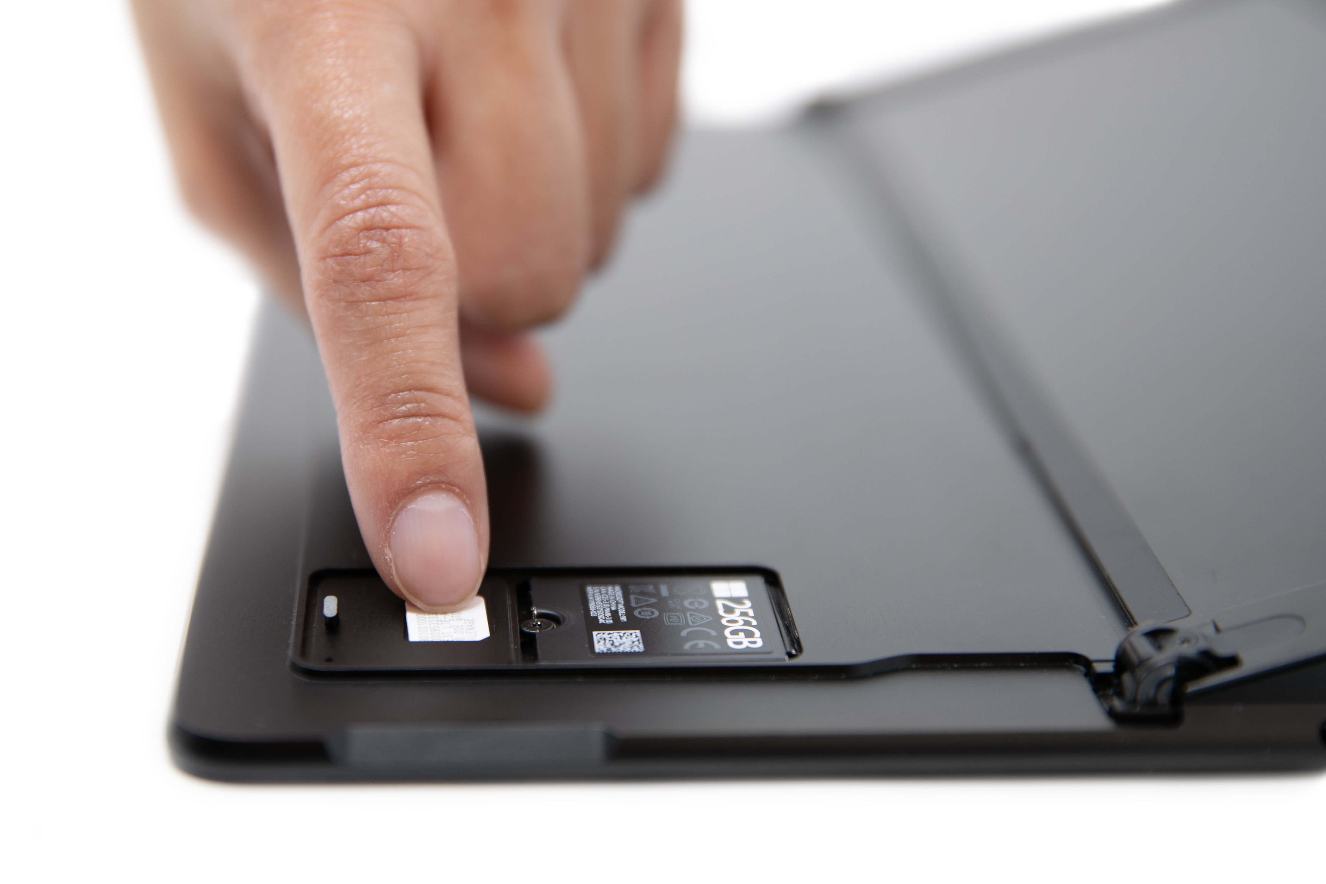 Una persona che fa scorrere una scheda SIM nello slot SIM di Surface Pro X.