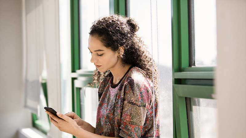 スマート フォンを持っている女性の画像。