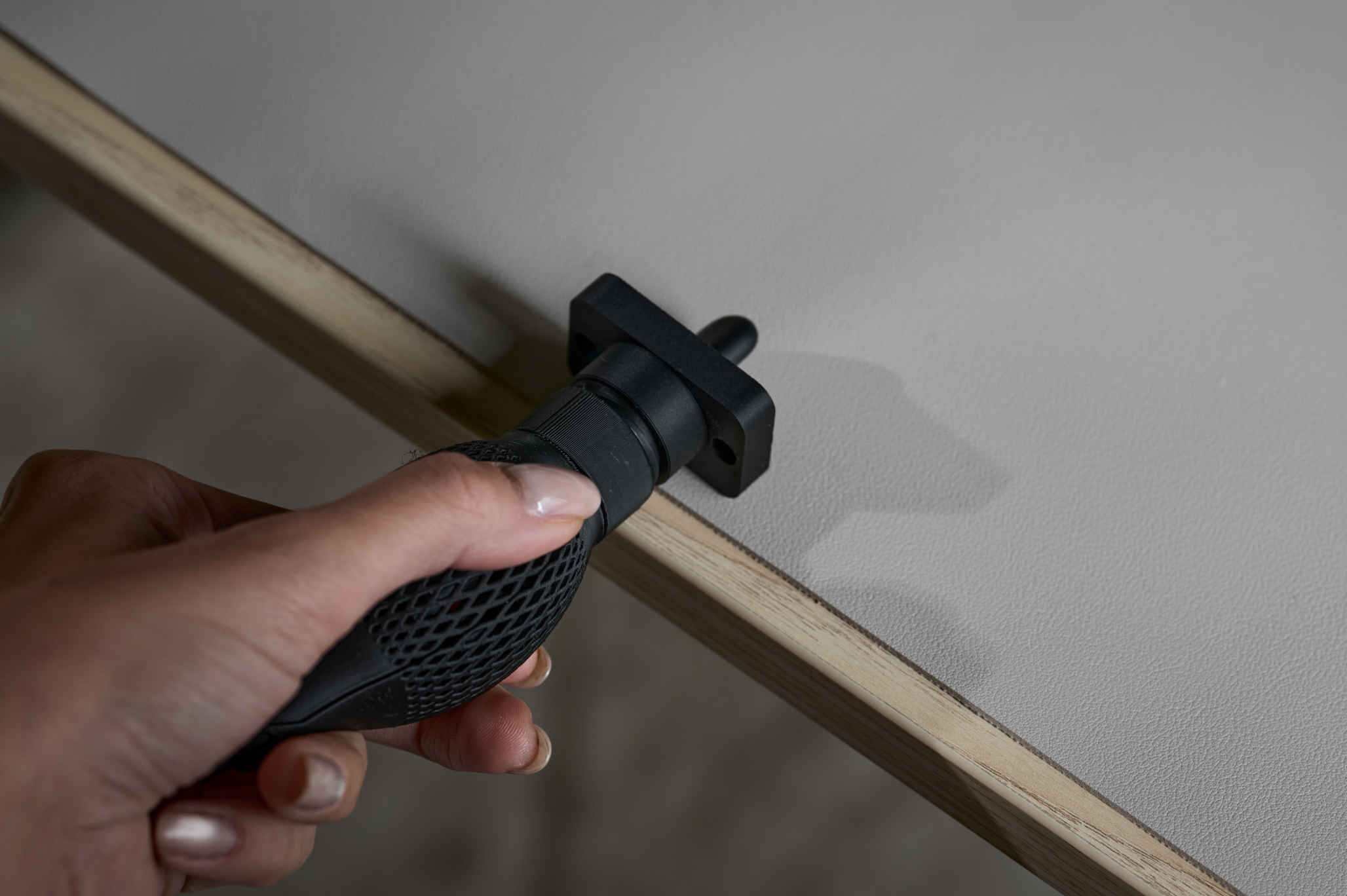 Een hand gebruikt de rand van een tafel om met één hand aan de dop te draaien.