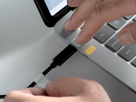 Muž, ktorý používa označenia portov, aby pripojil kábel USB-C k portu USB-C.