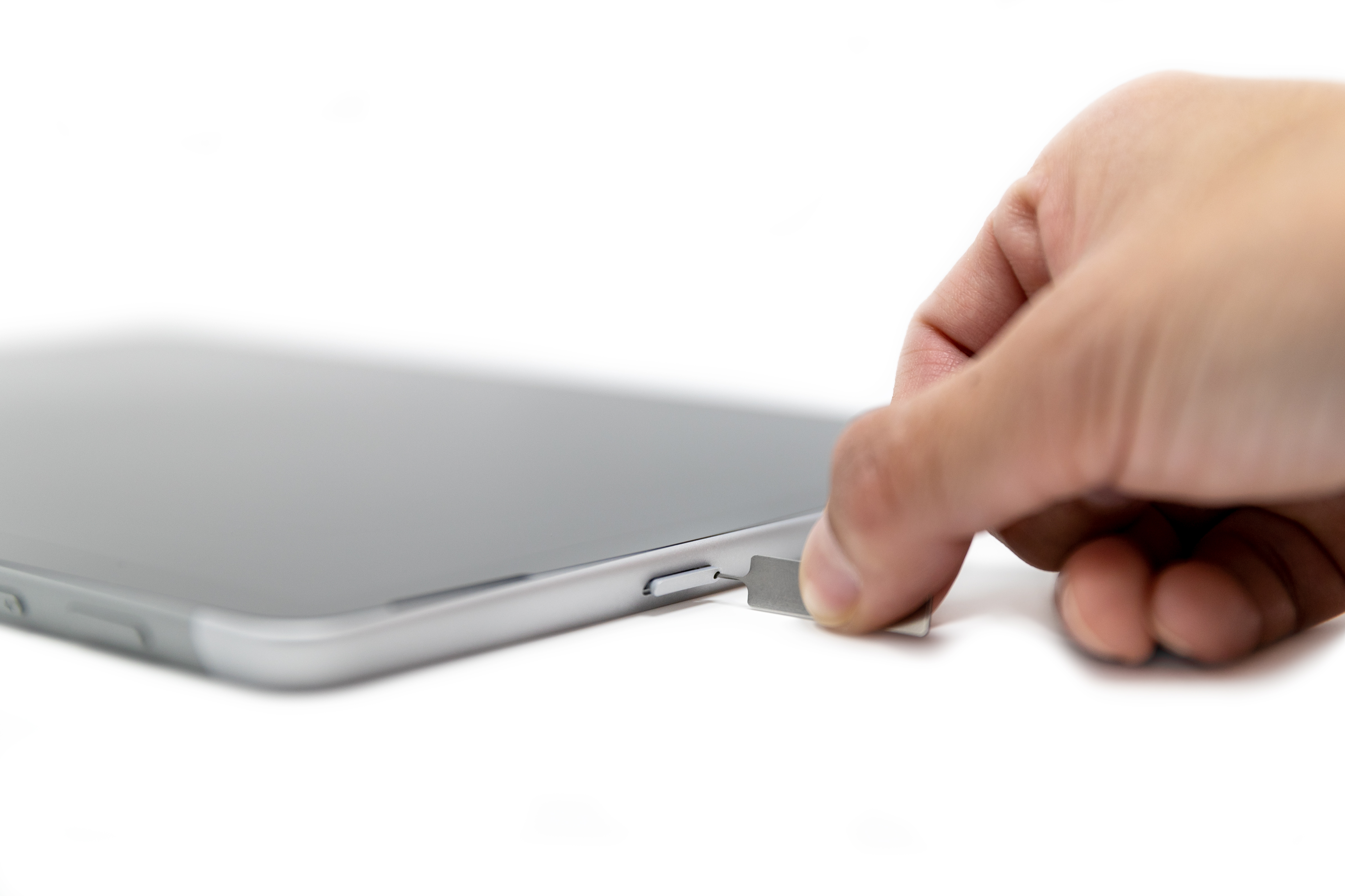 Oseba vstavlja pin SIM v režo kartice SIM naprave Surface Go 2.