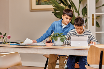 Hai học sinh trẻ tuổi nhìn vào thiết bị Microsoft Surface