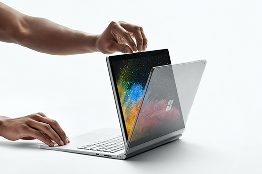 雙手打開處於檢視模式的 Surface Book 2 的圖片。